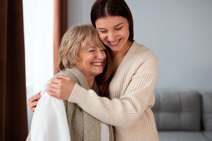 Two women smiling and hugging warmly, capturing a moment of kindness and being a good person.