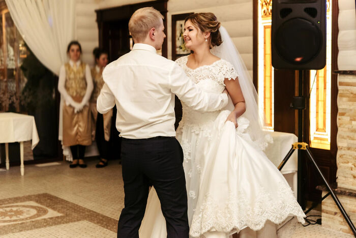 Bride and groom dancing at a wedding reception while guests watch, capturing moments hinting at a future breakup.