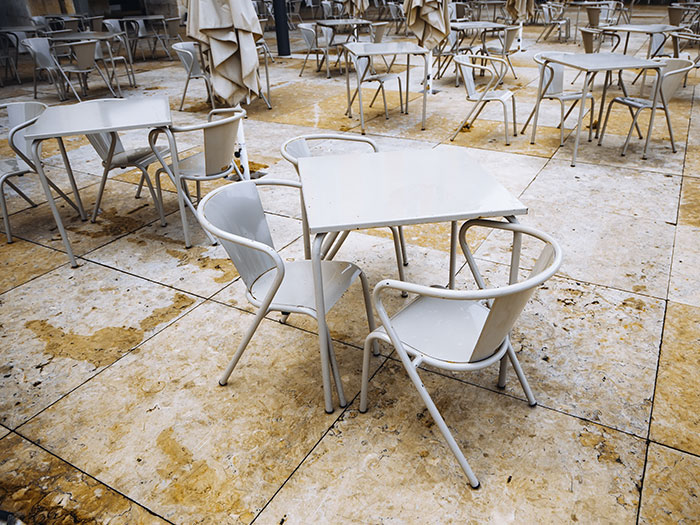 An empty outdoor cafe with tables and chairs, evoking the quiet aftermath of a horrible first date or closed for the day.