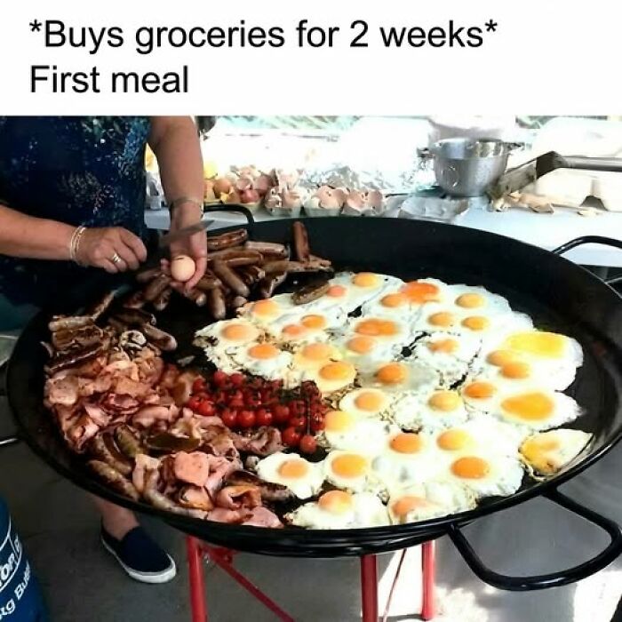 Large pan filled with cooked eggs, sausages, bacon, and tomatoes being prepared, showcasing food memes with quick chuckles.