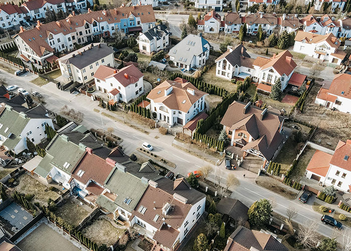 Aerial view of suburban neighborhood houses and streets illustrating signs the economy is not doing well.