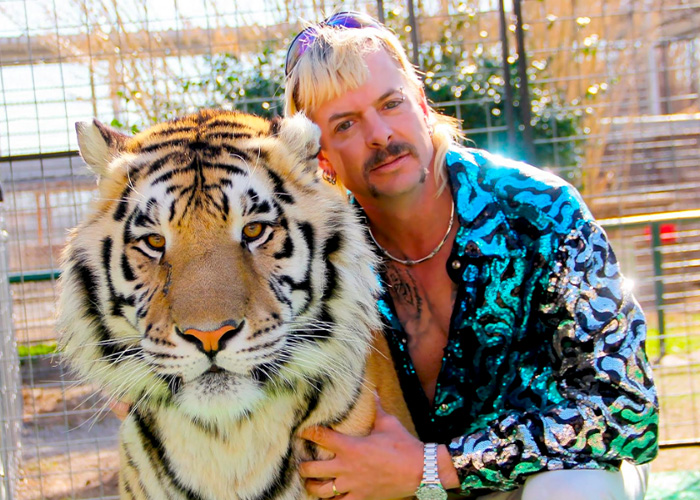 Joe Exotic, in a sequin shirt, holding a tiger. Things that went down 6 years ago, like Tiger King.