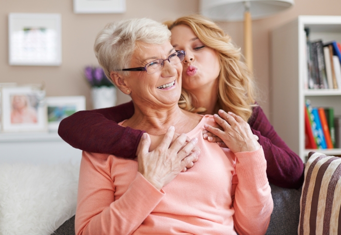 Woman embracing elderly female friend, showing close bond with family in a warm and cozy home setting. Woman embracing elderly female friend, showing close bond with family in a warm and cozy home setting.