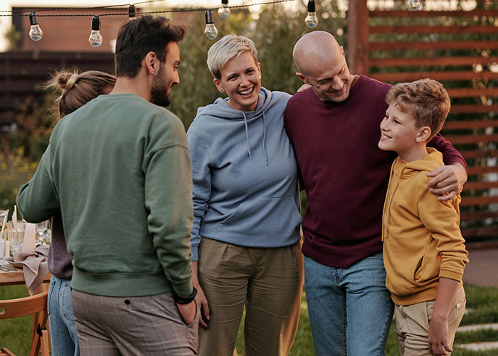 Group of people outdoors with a man making family as uncomfortable as possible after they refuse to leave his house