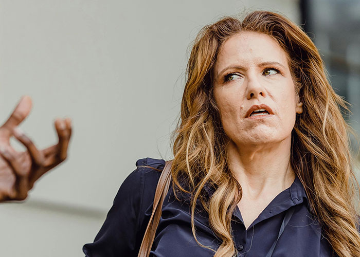 Woman with an entitled expression assuming a random guy will buy her kids food because she&rsquo;s a single mom, outdoors.