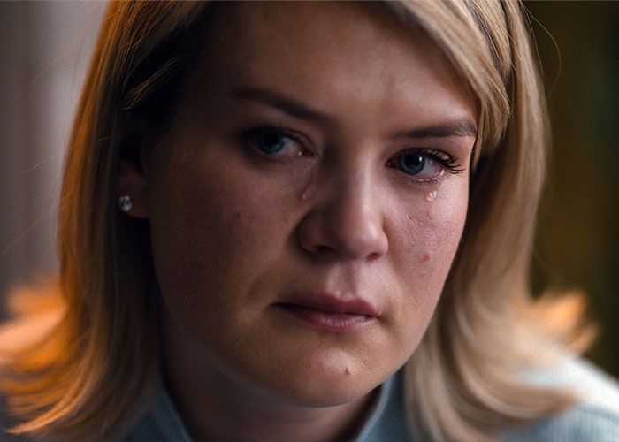 Close-up of a devastated bride-to-be with tears, revealing her fianc&eacute;&rsquo;s horrific crimes before their wedding day.