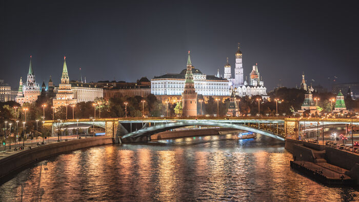 Illuminated Moscow Kremlin, bridge over Moskva River at night. Reflects a country with worst work-life balance.