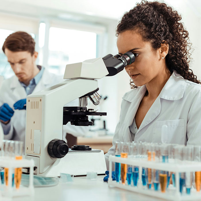 Um cientista olhando para um microscópio em um laboratório, pesquisando o tratamento do Alzheimer. Comer ovos para tratamento.