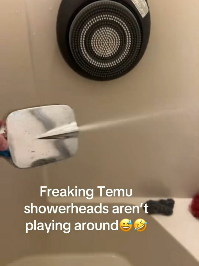 Temu showerhead spraying a strong stream of water in a bathroom, illustrating a funny product surprise.