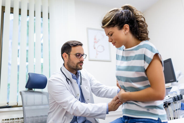 Doctor examining woman in clinic, revealing random facts about their bodies during a visit for different issues.