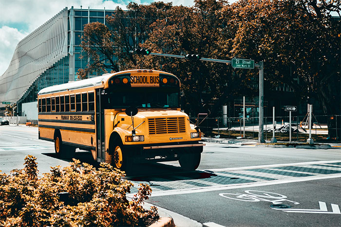 Yellow school bus driving through an urban street with autumn trees, illustrating a man's creepy confession starting at age 12.
