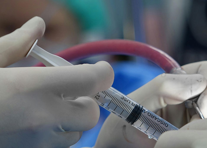 Close-up of gloved hands holding a syringe and medical tubing, highlighting things more dangerous than they seem.