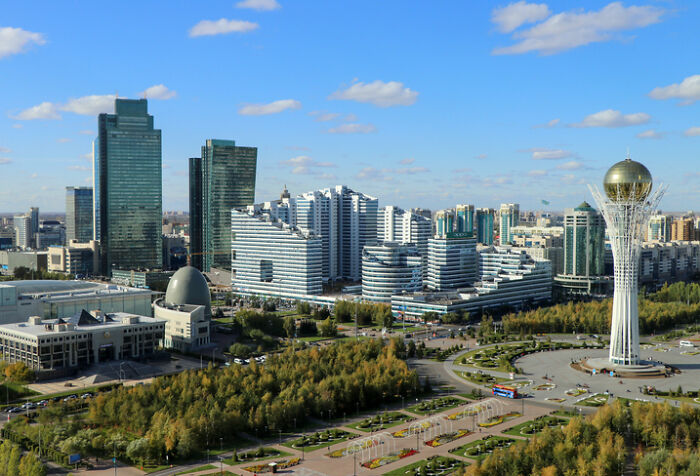 Astana's modern skyline with tall buildings, green parks, and the iconic Bayterek Tower. Visualizing countries with worst work-life balance.
