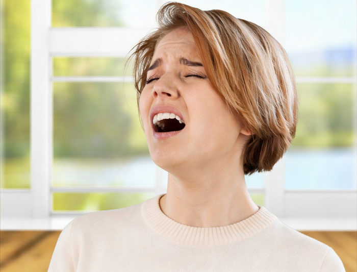 A woman making a disgusted expression, likely from a gross office story, looking like she might throw up.