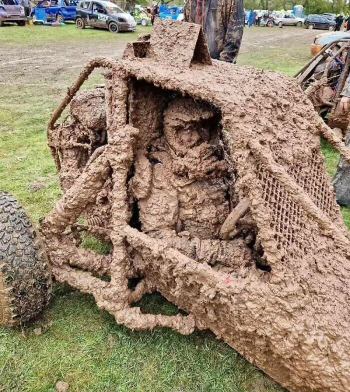 A weird image of a mud-caked buggy and driver after a race, a sight that will live in your mind rent-free.