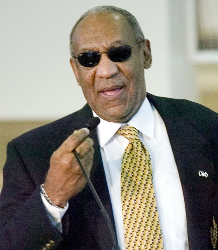 Man in sunglasses and suit speaking at a microphone, illustrating companies not thinking through social media campaigns.