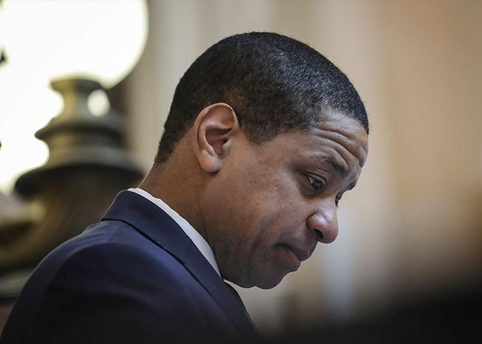 Ex-Virginia Lt. Governor Justin Fairfax in a suit, appearing thoughtful amid a case involving holes in her shirt and a 911 call.