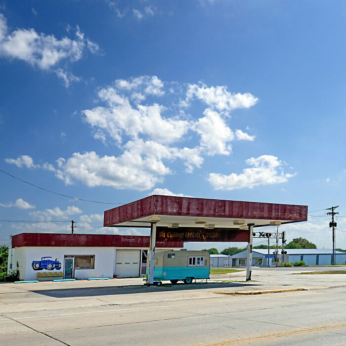 Abandoned gas station with faded red canopy and a small trailer, one of the worst places in the US people have visited.