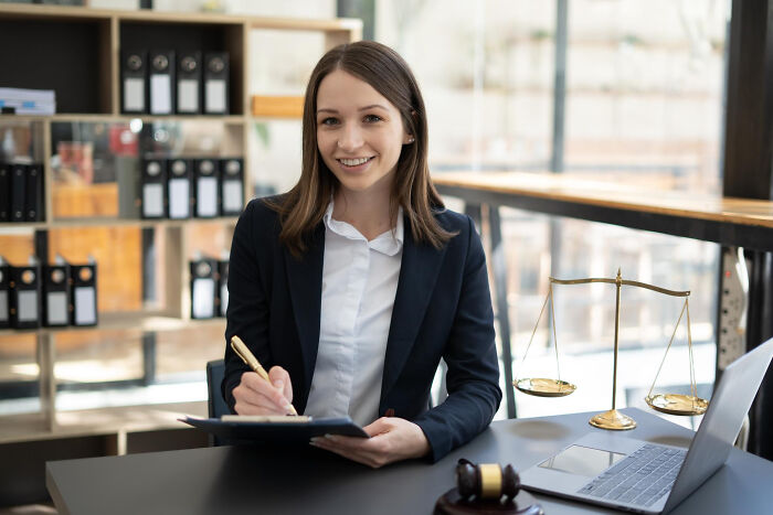 Young professional woman showcasing inspiring comebacks and thriving success in a modern office with legal symbols.