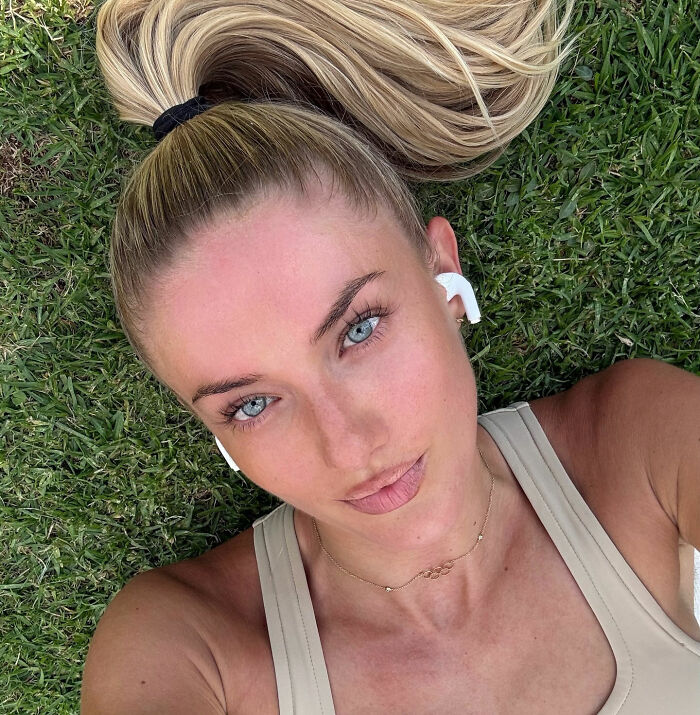 Alica Schmidt deitada na grama com fones de ouvido, mostrando um close do rosto e cabelos loiros da atleta mais sexy do mundo. Alica Schmidt deitada na grama com fones de ouvido, mostrando um close do rosto e cabelos loiros da atleta mais sexy do mundo.