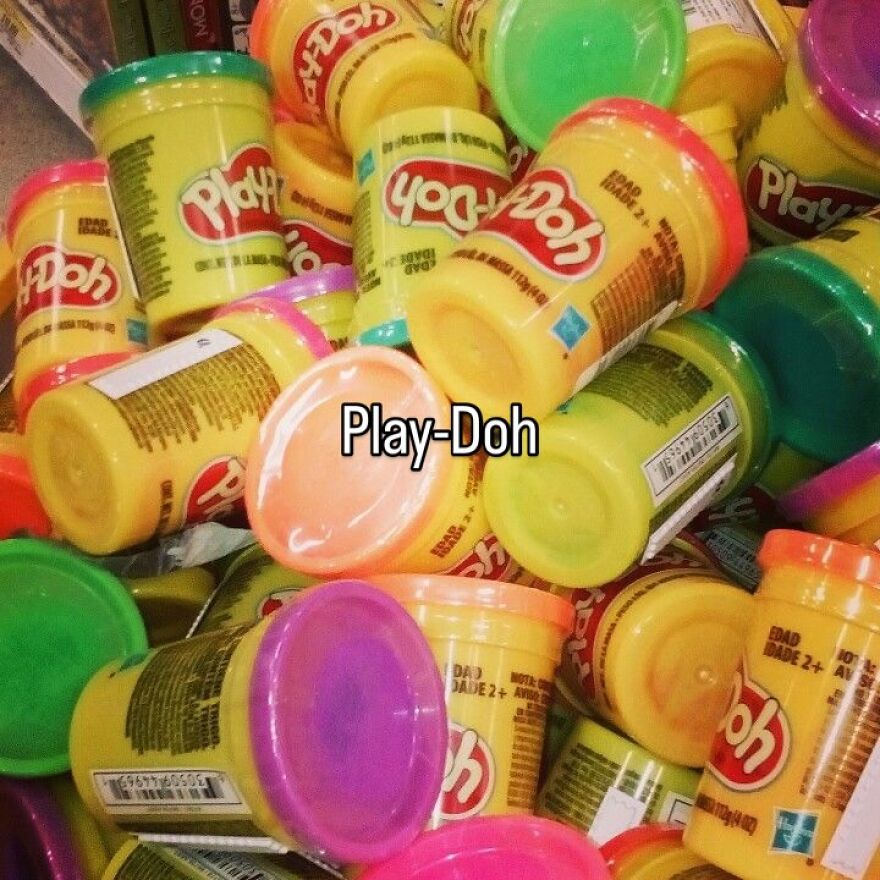 A pile of colorful Play-Doh tubs, evoking nostalgia and the vibe of growing up in the 2000s.