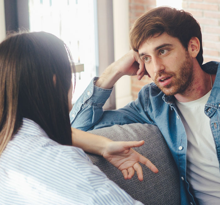 Man looking uncomfortable as a woman talks to him in a casual setting depicting ways women make men feel uncomfortable.