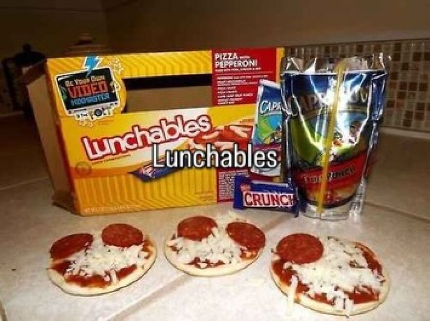 A Lunchables pizza kit, Capri Sun, and Crunch bar on a counter, evoking nostalgic photos of growing up in the 2000s.