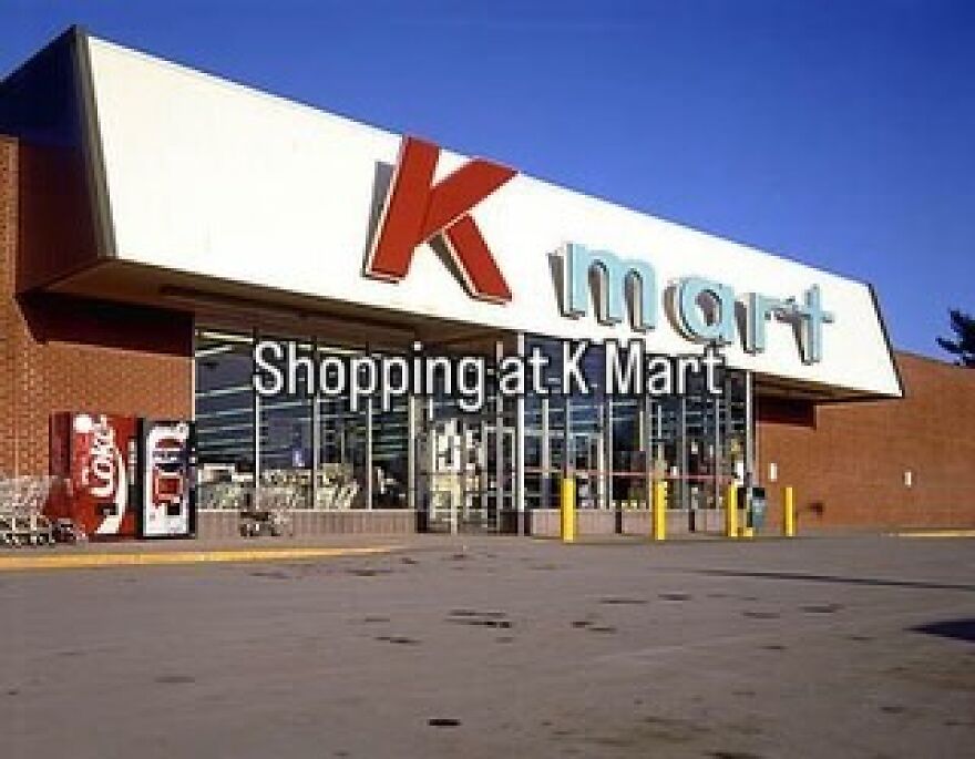 An exterior shot of a Kmart store, a nostalgic photo of growing up in the 2000s, with a large parking lot.