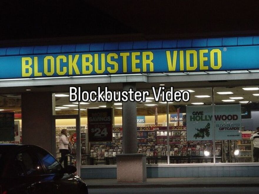 An exterior shot of a Blockbuster Video store at night, capturing the nostalgic vibe of growing up in the 2000s.