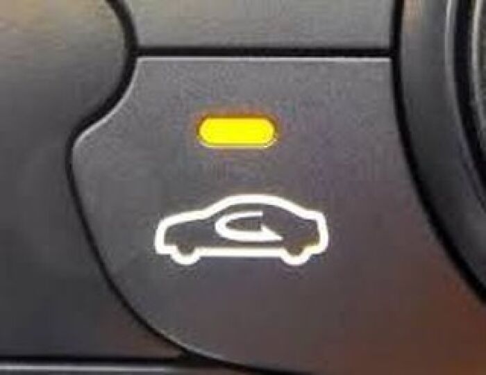 Car dashboard button with interior air circulation icon illuminated in yellow light, illustrating tips and tricks parents share.