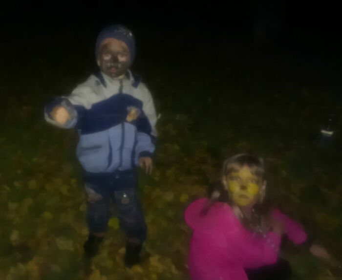 Two kids with messy faces outdoors at night, a funny and chaotic childhood photo capturing a playful moment.