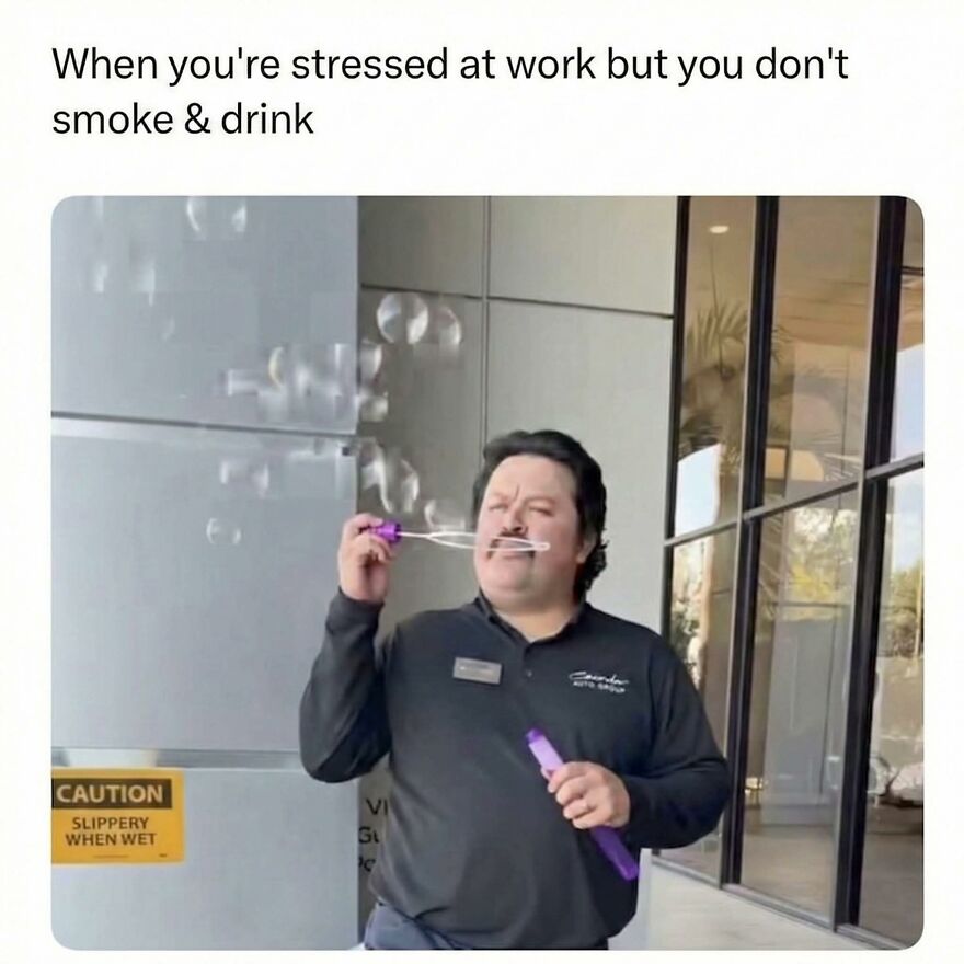 Man blowing bubbles outside a building, illustrating a work meme about stress without smoking or drinking at a job.