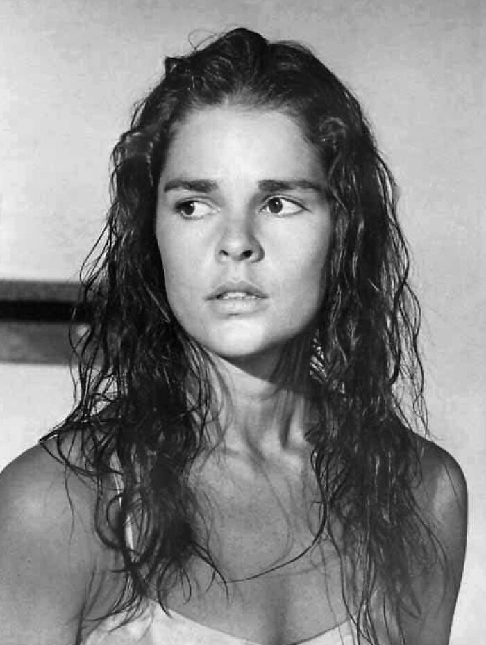 Ali MacGraw in a classic black and white portrait with wet hair, showcasing her striking natural beauty and presence.