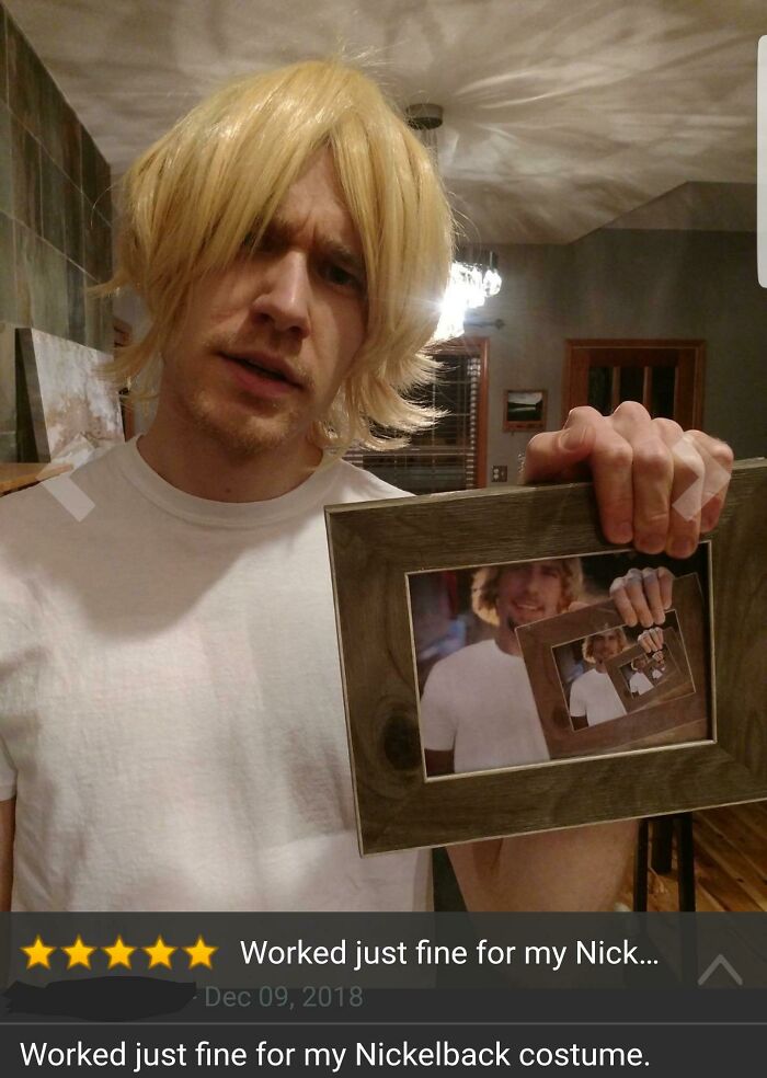 Man in a blonde wig holding a framed photo showing a recursive image, related to funny Amazon reviews and eyeliner humor.