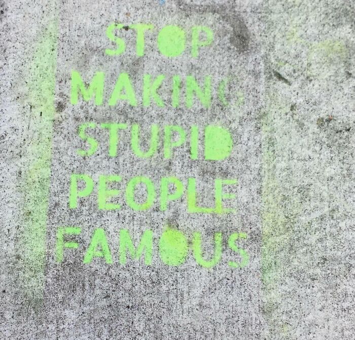 Green graffiti on a concrete surface with funny pieces of advice about not making stupid people famous.