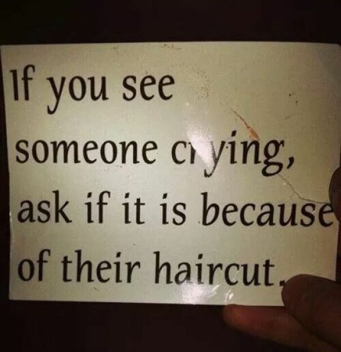 Hand holding a worn card with funny advice about asking if someone is crying because of their haircut.