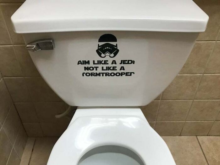 Toilet with a funny piece of advice decal saying aim like a Jedi not like a Stormtrooper, showing humor in advice.