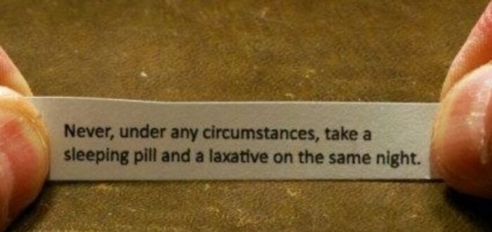 Fortune cookie with funny advice about not taking a sleeping pill and a laxative on the same night as humorous advice.