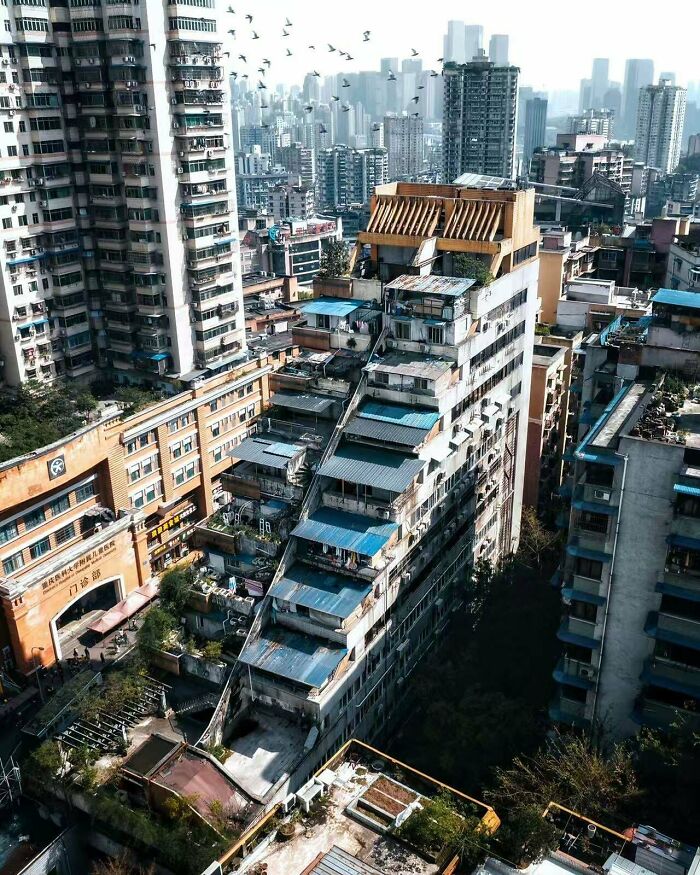 Dense urban hell cityscape with aged, layered buildings and modern skyscraper background