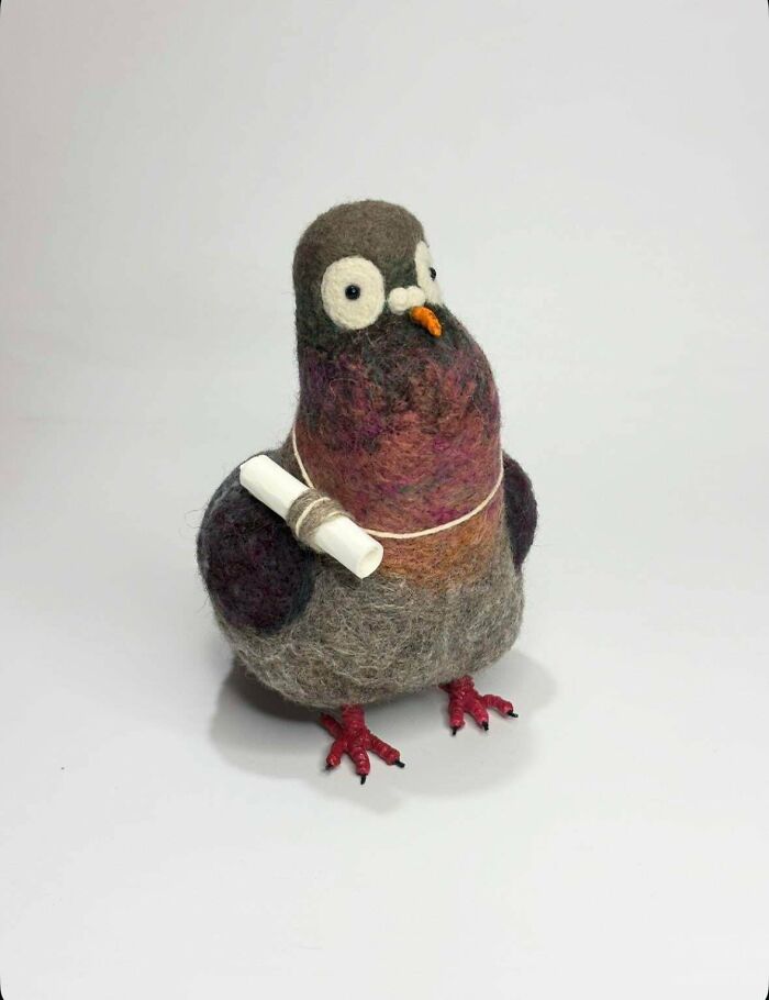 A handmade felt pigeon holding a rolled-up message, showcasing talent and patience in a charming project.