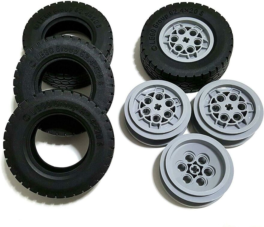 LEGO tires and wheels arranged on a white surface, showcasing details for fun facts and learning interest.