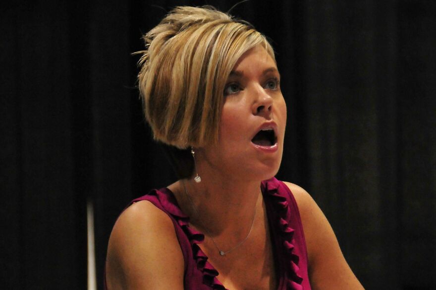 Woman with short blonde hair in a purple top expressing surprise while sharing interesting and fun facts about learning joy.
