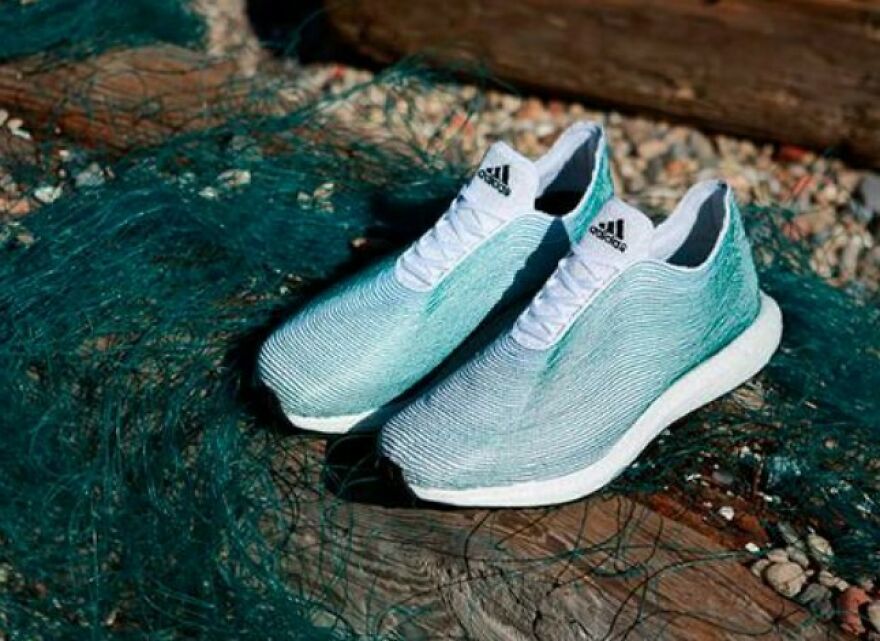 Light blue Adidas sneakers placed on a rustic wooden surface with a fishing net, combining style and interesting fun facts.