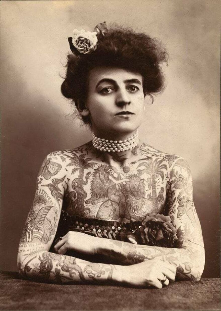 Vintage portrait of a heavily tattooed woman showcasing interesting and fun facts through historical body art designs.