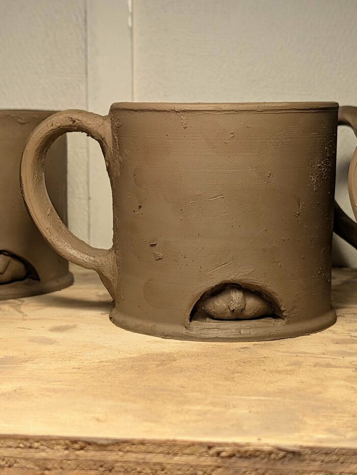 A handmade clay mug with an eye inside a small cave at the bottom. This project took talent and patience.