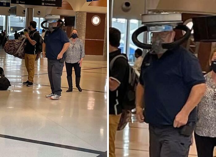 A man at a chaotic airport wearing a large, unusual, homemade air filtration device over his head.