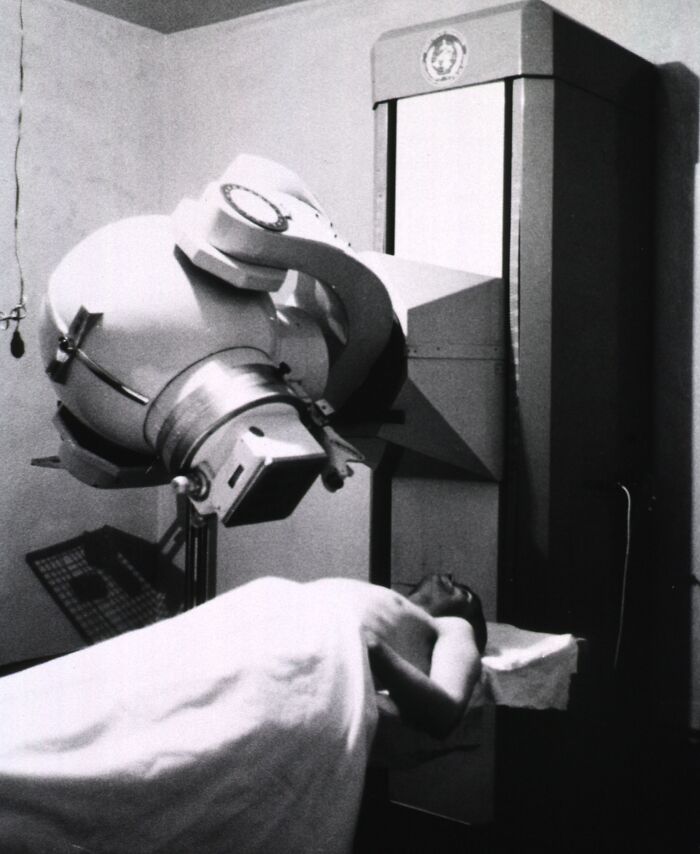 Vintage medical device from the past in use, showing early healthcare technology with a patient on a treatment table.