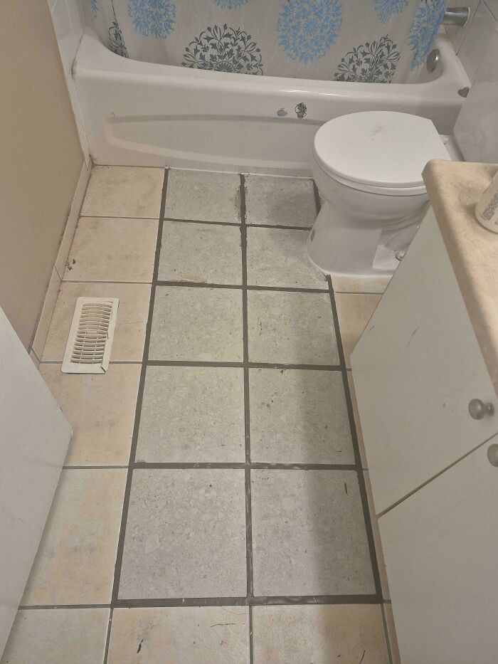 A bathroom floor with mismatched tiles, illustrating a funny you had one job fail.
