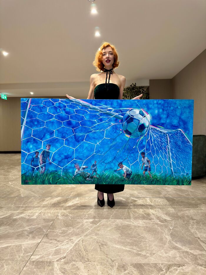 Interesting post: a woman holding a large painting of a soccer goal, offering a break from everything.