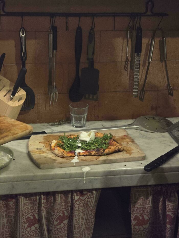 Flatbread pizza on a cutting board, reminiscent of Accidental Renaissance art.